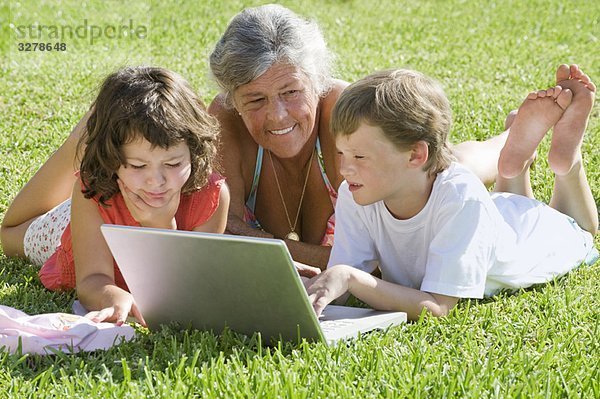 Seniorin mit Kindern am Laptop