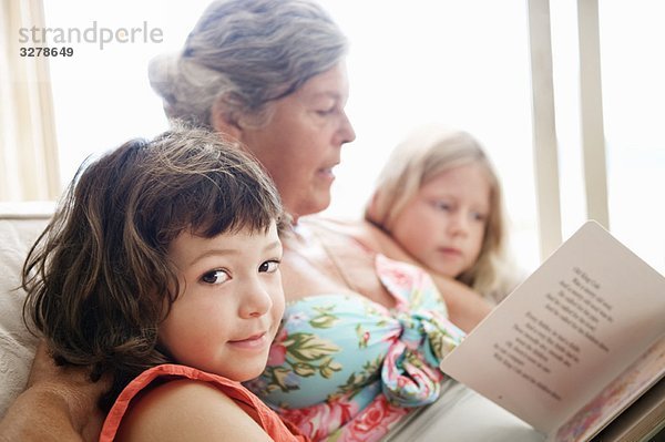 Eine ältere Frau liest einigen Kindern vor.
