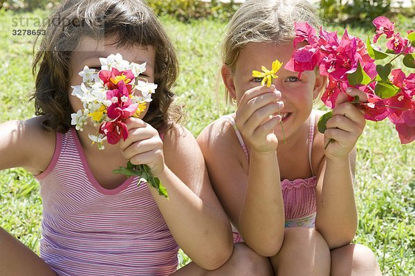 Zwei junge Mädchen mit einigen Blumen