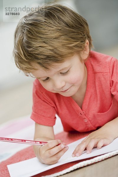 Junge auf dem Boden malen mit Stift