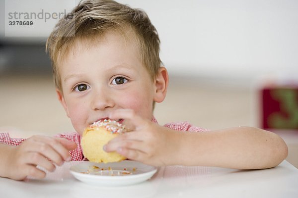 Junge isst süße Knödel