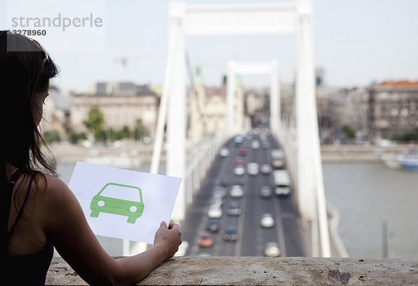 Frau hält Papier grünes Auto