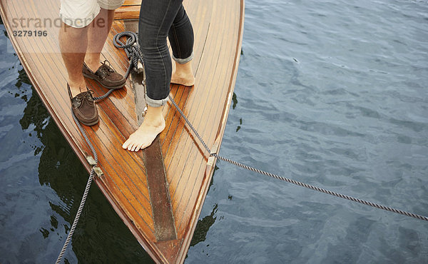 Füße eines Paares mittleren Alters auf einem alten Boot