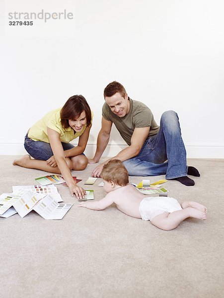 Junge Familie auf dem Boden mit Farbmustern