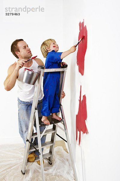 Mann und Kleinkind Junge malen Wand rot