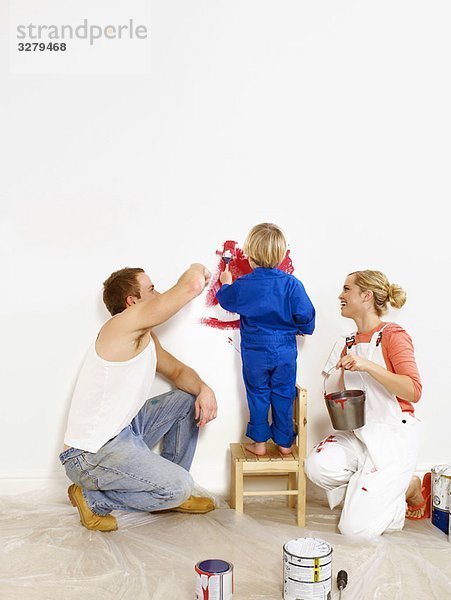 Paar und Kleinkind Jungen malen Wand