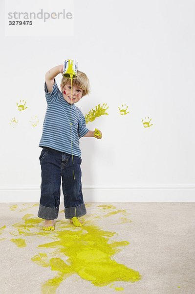 Kleinkind Junge gießt Farbe auf den Teppich