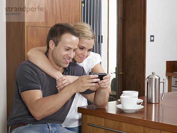 Pärchen beim Kaffeetrinken am Telefon