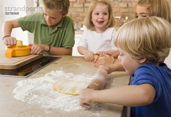 vier Kinder backen Kekse