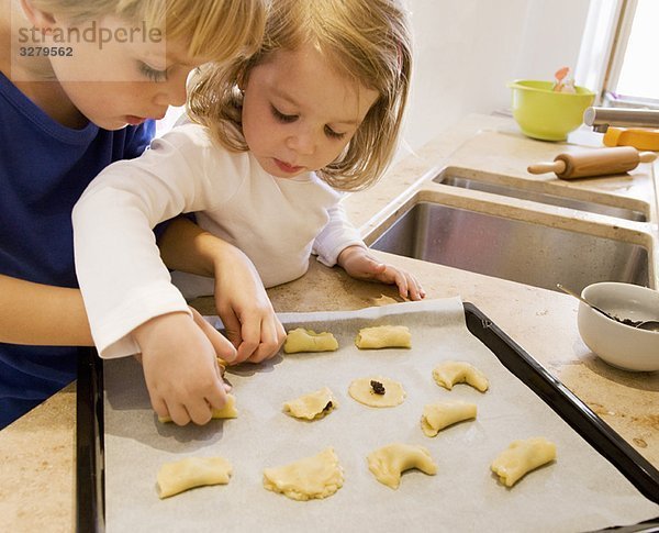 Mädchen  Junge bereitet Kekse zum Backen vor