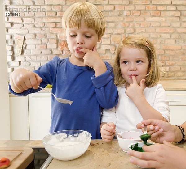 Mädchen  Junge schmeckt Backzutaten