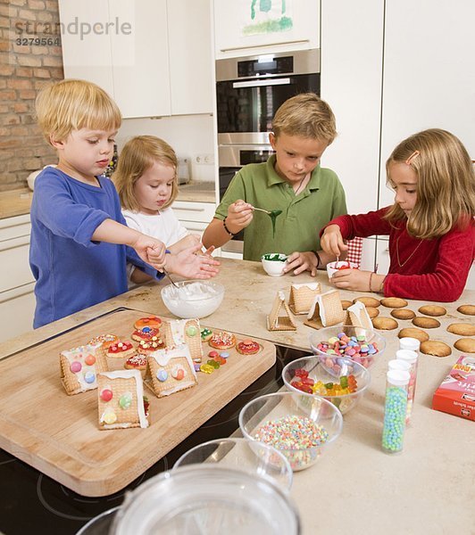 vier Kinder backen Kekse