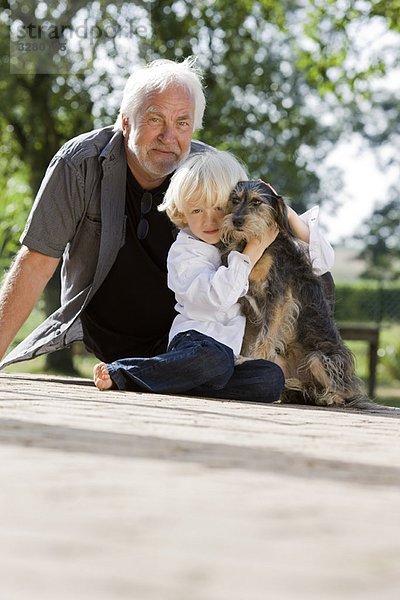 Großvater und Enkel mit Hund