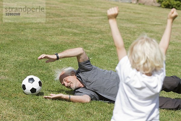 Großvater und Kind beim Fußballspielen