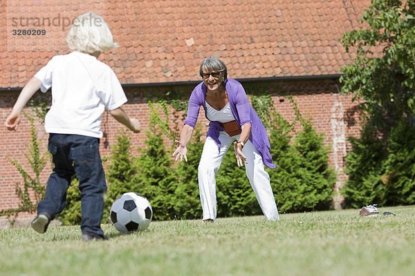 Großmutter und Kind beim Fußballspielen