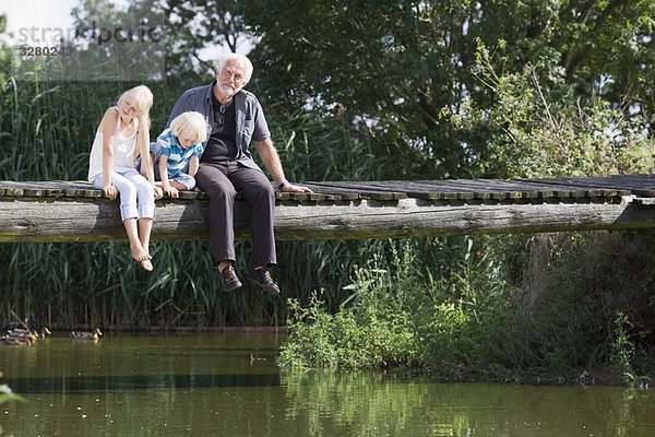 Großvater und Kinder auf dem Steg