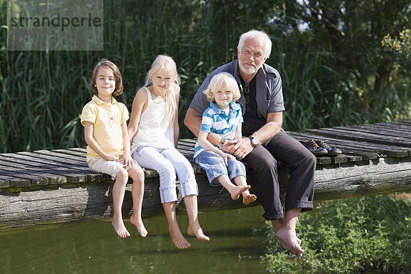 Großvater und Kinder auf dem Steg