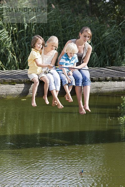 Kinder fischen vom Steg aus