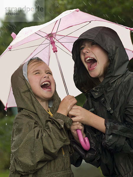Mädchen unter einem Regenschirm singen