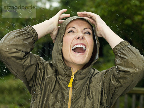 Eine Frau im Regen lächelnd