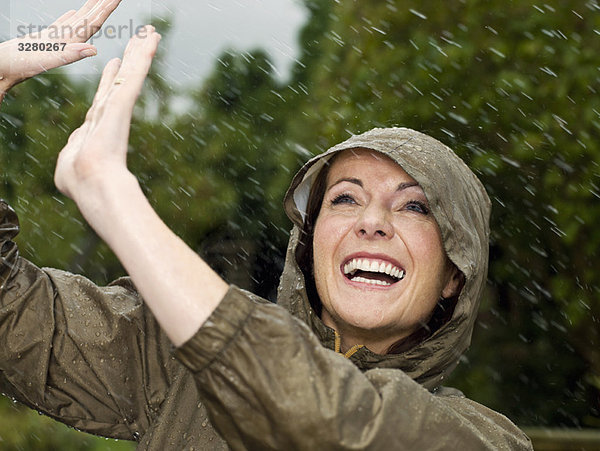 Eine Frau im Regen lächelnd