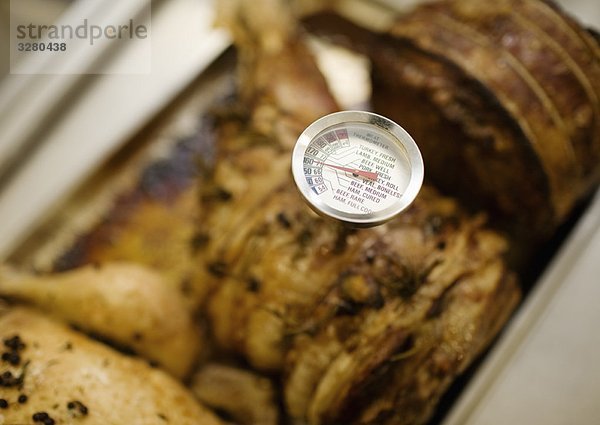 Ein Thermometer  das etwas Fleisch testet.