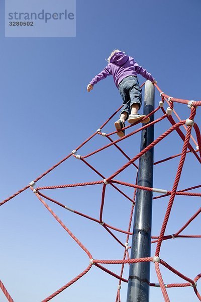 Junge klettert Dschungelgymnastik