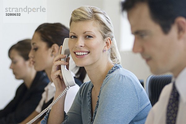 Eine Geschäftsfrau am Telefon lächelt