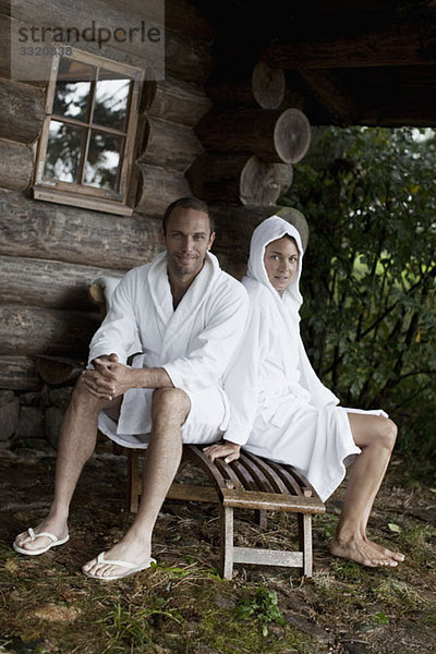 Ein Paar  das sich außerhalb der Sauna in einem Wellnessbereich entspannt