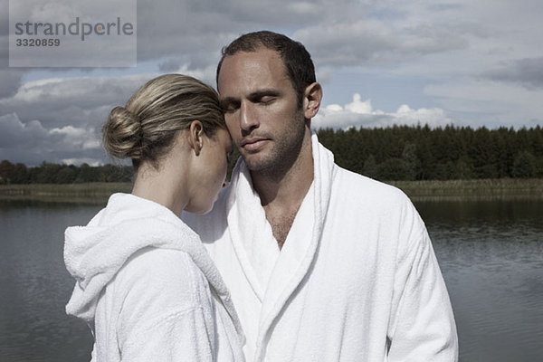 Ein Paar in Bademänteln in der Nähe eines Sees in einem Heilbad