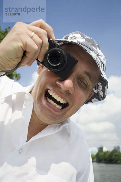 Ein ekstatischer Mann beim Fotografieren mit einer Digitalkamera
