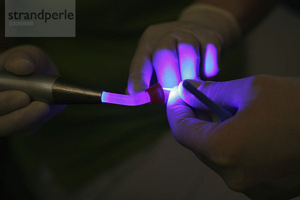 Detail eines Zahnarztes mit UV-Licht