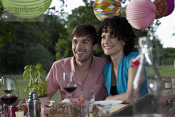 Ein Paar auf einer Dinnerparty  im Freien