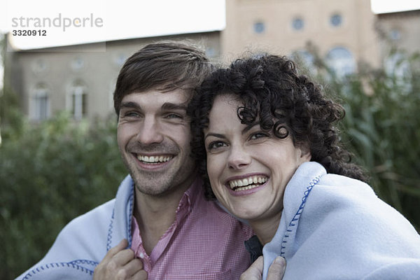 Ein Ehepaar in eine Decke gehüllt  lachend