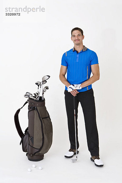 Ein Mann stehend mit Golfausrüstung