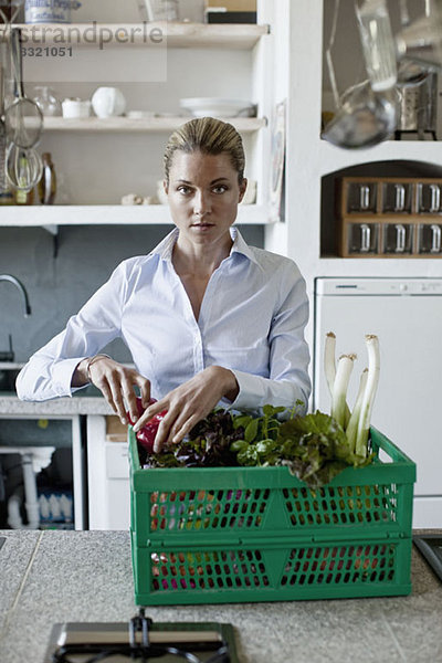 Eine Frau in der Küche mit einem Gemüsekorb