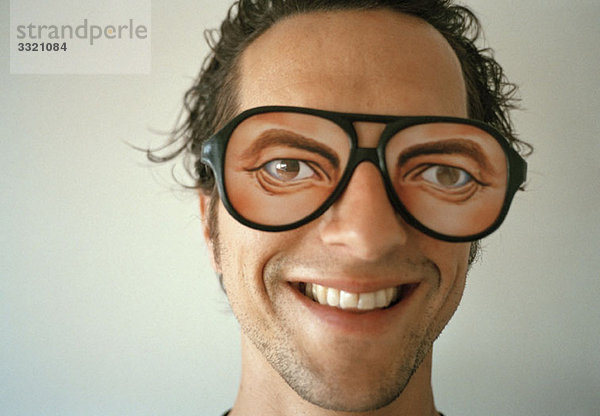Ein Mann mit einer neuen Brille und einem Lächeln.