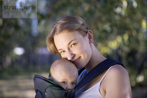 Eine Mutter mit ihrem Baby im Tragesitz  Porträt