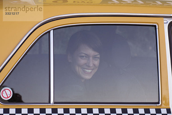 Eine Frau in einem Taxi lächelnd