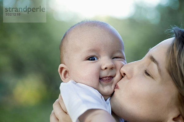 Eine Mutter  die ihren kleinen Jungen küsst.