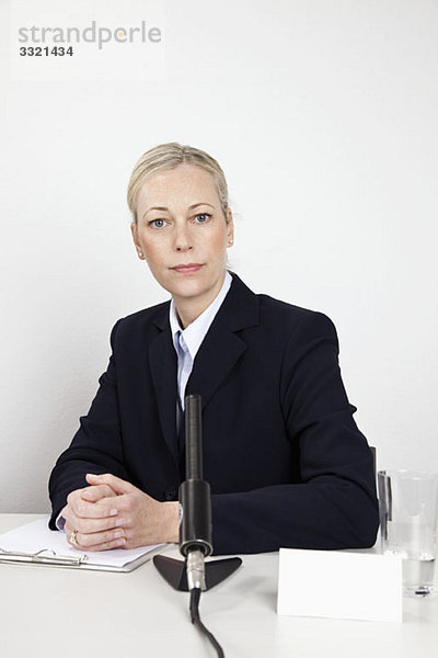 Eine Frau am Schreibtisch mit Mikrofon