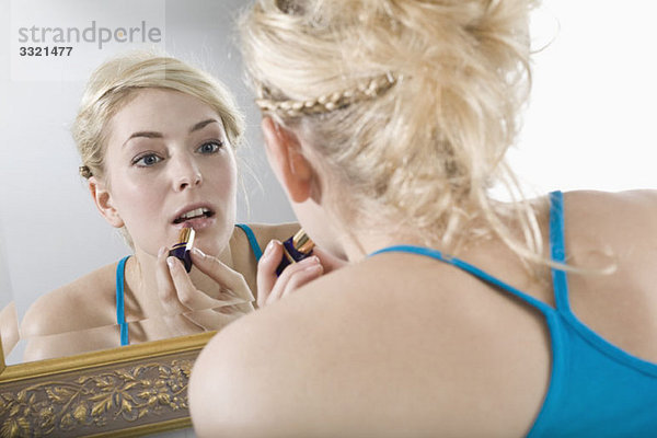 Eine Frau mit Lippenstift im Spiegel