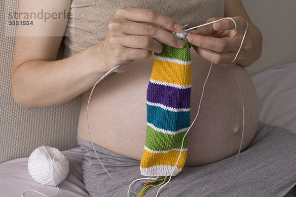 Eine schwangere Frau strickt  Mittelteil