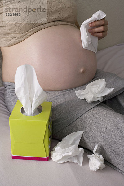 Eine schwangere Frau mit mehreren zerknitterten Geweben  Mittelteil