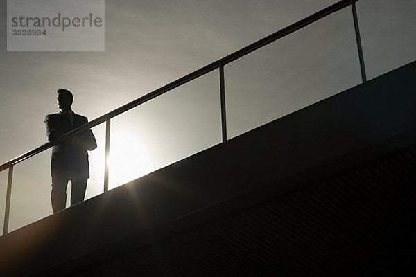 Silhouette eines Geschäftsmannes auf einer Brücke