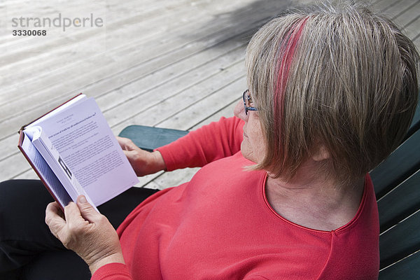 Frau lesen auf Cottage Deck  Algonquin Park  Ontario