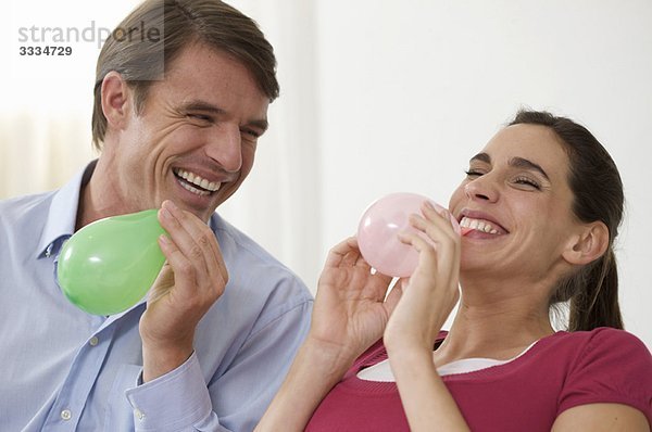 ein Paar mit Spaß beim Ballonblasen