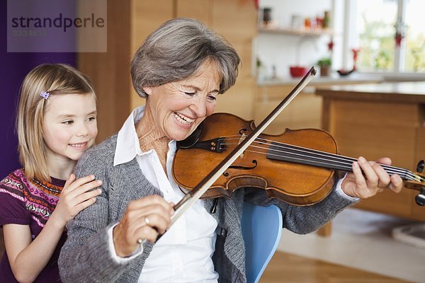 Enkelkind schaut Oma beim Musizieren zu