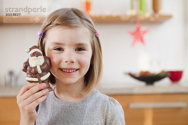 junges Mädchen mit Schoko-Weihnachtsmann