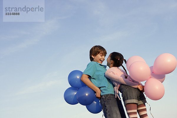 Kinder lachen mit Luftballons